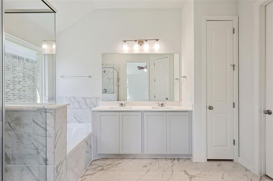 Bathroom with vanity, vaulted ceiling, independent shower and bath, and ceiling fan