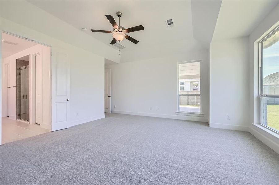 Spare room featuring light colored carpet, a ceiling fan, and baseboards Spare room featuring light colored carpet, a ceiling fan, and baseboards
