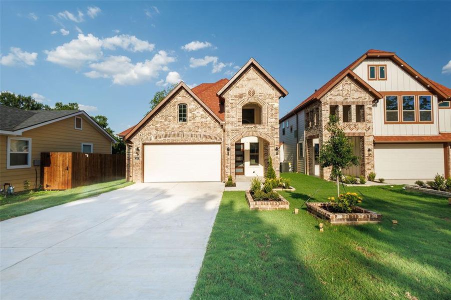 View of front facade featuring concrete driveway, brick siding, and board and batten siding