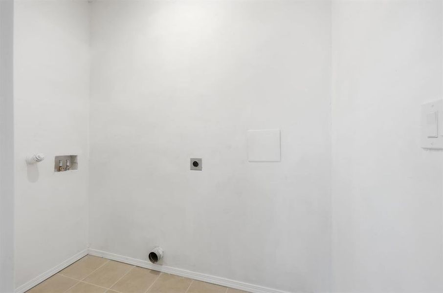 Separate laundry room with light tile patterned flooring, washer hookup, and hookup for an electric dryer
