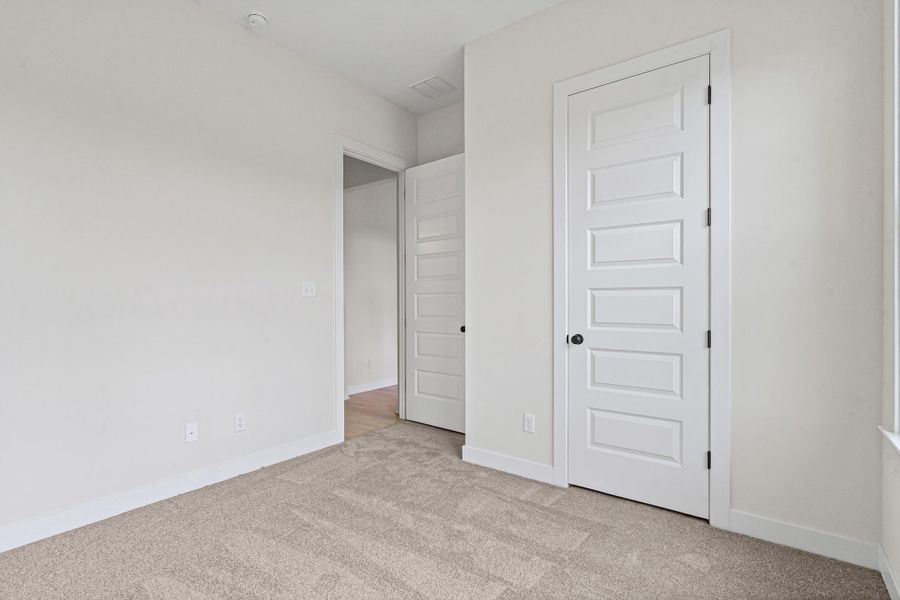 Neutral-toned carpet flooring and white baseboards Neutral-toned carpet flooring and white baseboards