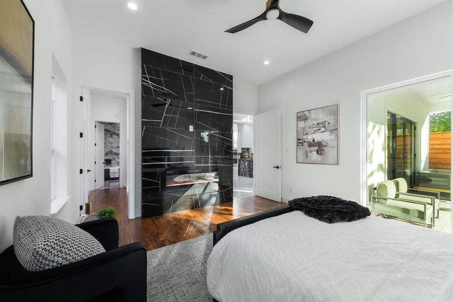Primary bedroom on the 1st level with its own fireplace, recessed lighting, a ceiling fan, and access to the back patio. Primary bedroom on the 1st level with its own fireplace, recessed lighting, a ceiling fan, and access to the back patio.