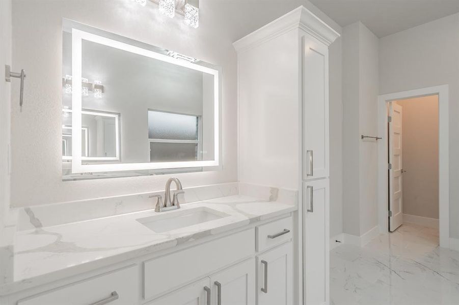 Full bath featuring light marble finish flooring and vanity