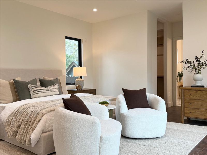 Recessed ceiling lighting illuminates the spacious room with wood-finish flooring