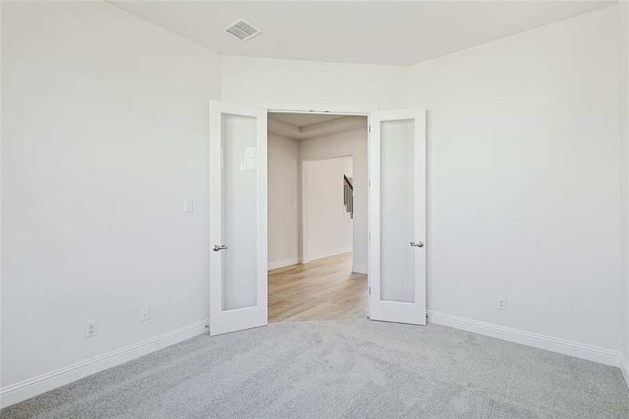 Unfurnished bedroom with light colored carpet