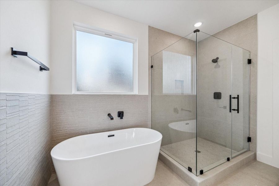 Massive primary bathroom with large stand-alone shower and tub. Massive primary bathroom with large stand-alone shower and tub.