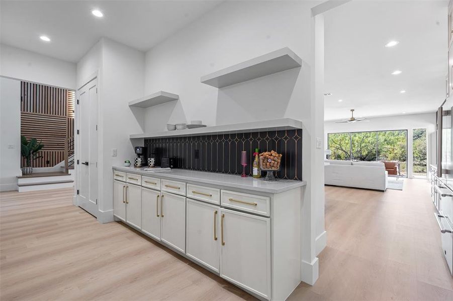 Bar area with open shelves, recessed lighting, light wood-style floors, white cabinetry, and ceiling fan