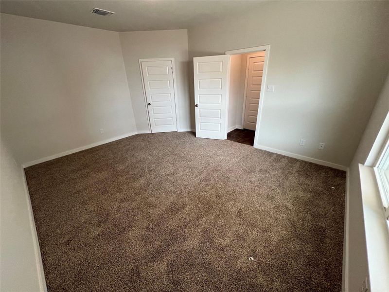 Unfurnished bedroom with dark carpet and a closet Unfurnished bedroom with dark carpet and a closet