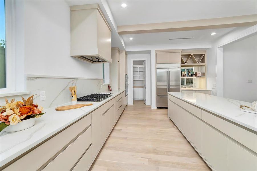 Kitchen featuring stainless steel appliances, modern cabinets, light wood finished floors, recessed lighting, and light stone counters Kitchen featuring stainless steel appliances, modern cabinets, light wood finished floors, recessed lighting, and light stone counters