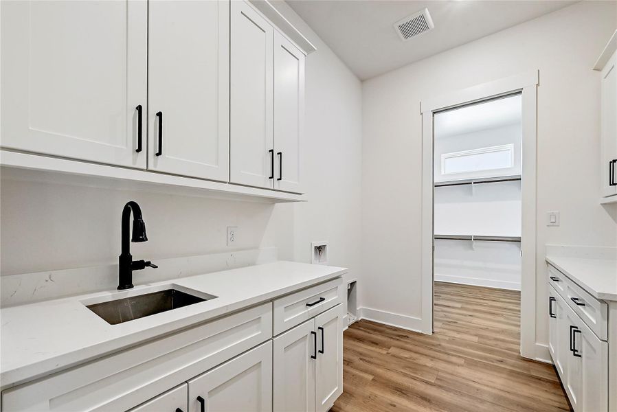 Laundry room opens to master closet and has lots of cabinet and counterspace for a large family's needs.