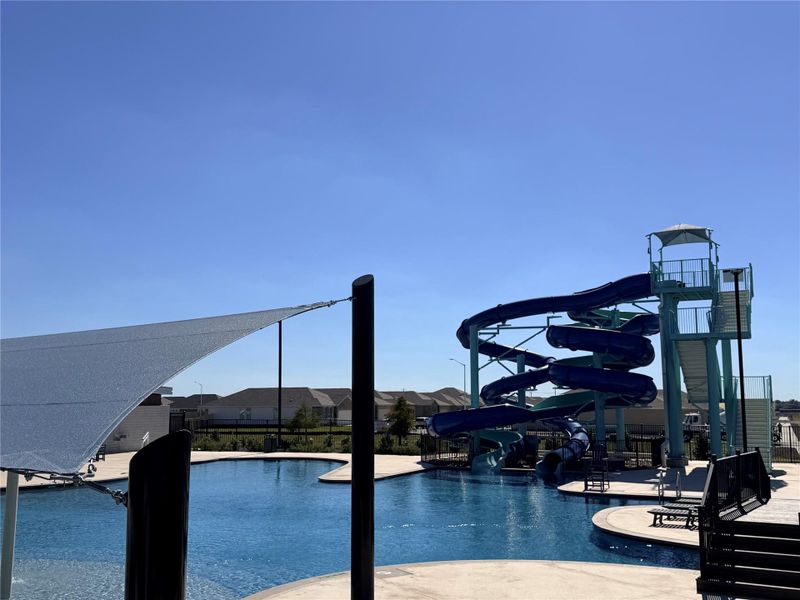 Community pool featuring a water slide and a patio Community pool featuring a water slide and a patio
