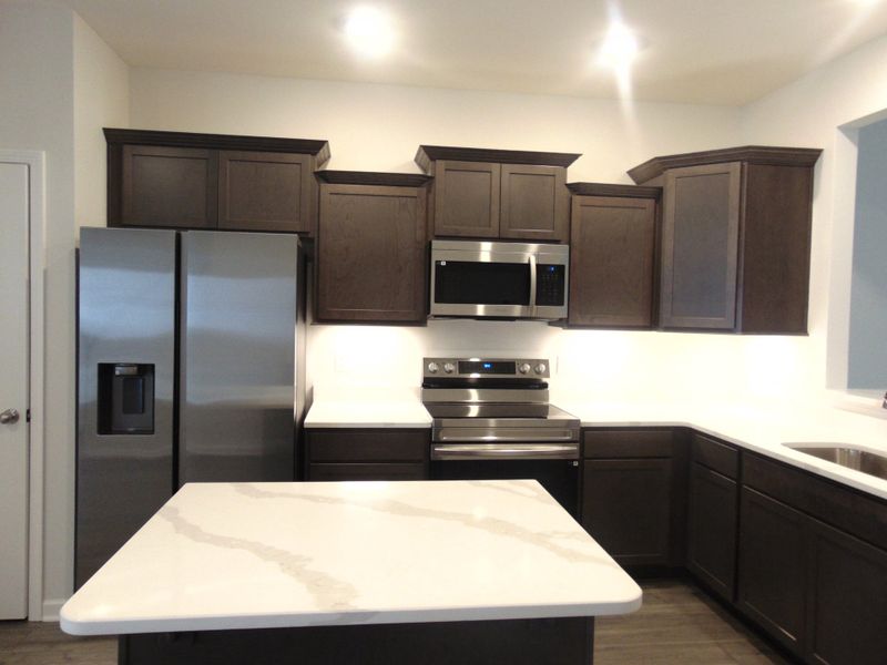 The kitchen is spacious and modern, it comes with steel appliances, and crown cabinetry for a unique look