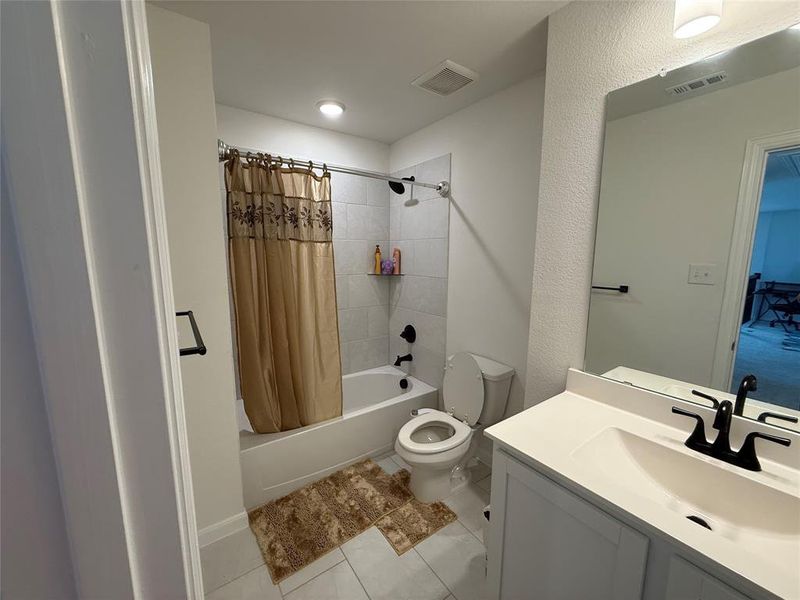 Bathroom featuring a white vanity with an integrated sink, matte black faucet, and a large wall mirror