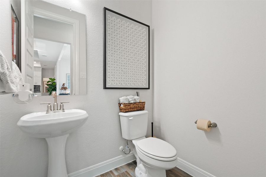 A pristine powder room offers a sleek pedestal sink and contemporary decor. A pristine powder room offers a sleek pedestal sink and contemporary decor.