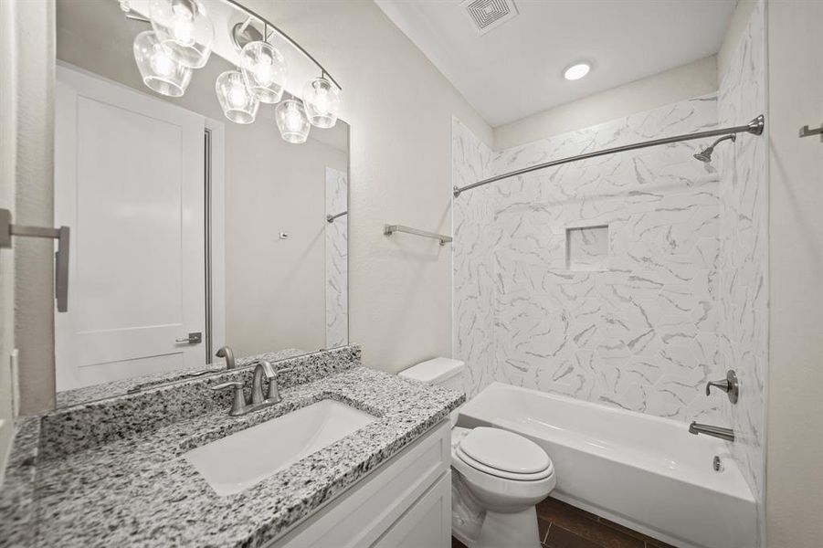 Secondary Bathroom with tile floors, a shower/tub combo with recessed lighting, granite countertops, and a large mirror.