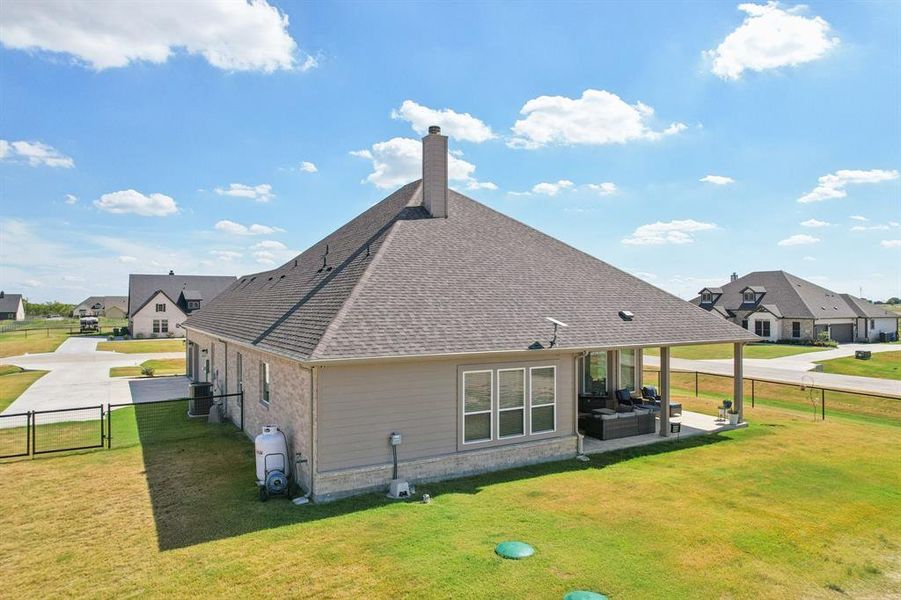 Back of property featuring a gate and a fenced backyard