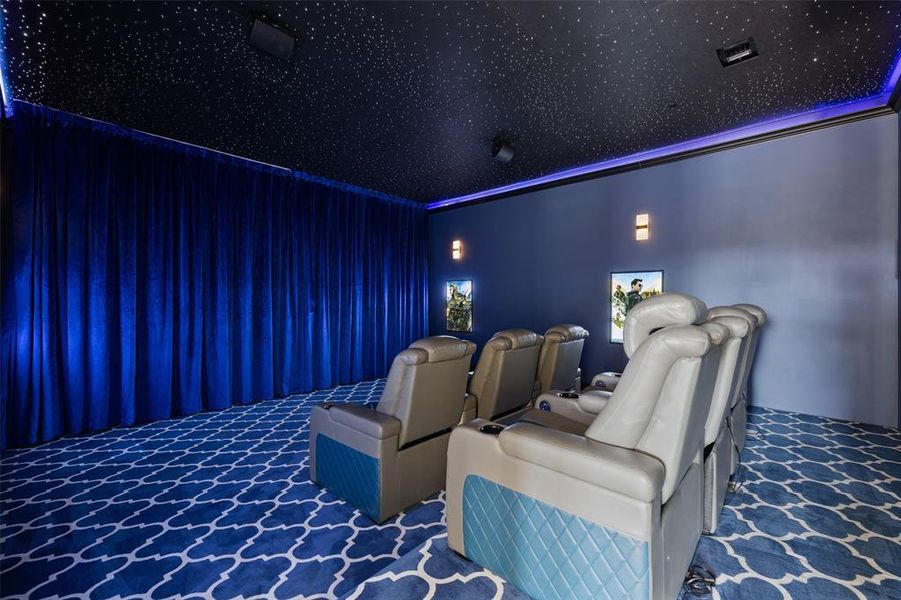 Carpeted home theater room featuring a towering ceiling