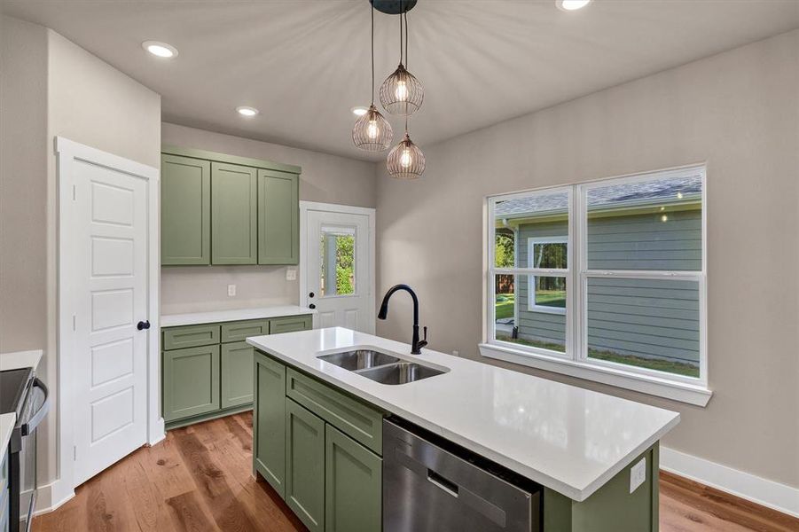 Kitchen with green cabinets, pendant lighting, dark wood-style flooring, appliances with stainless steel finishes, and recessed lighting Kitchen with green cabinets, pendant lighting, dark wood-style flooring, appliances with stainless steel finishes, and recessed lighting