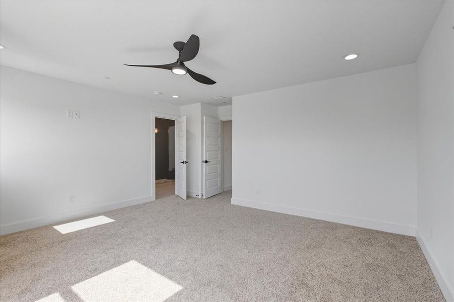 Primary bedroom with plenty of natural light, light carpet, a ceiling fan, and recessed lighting