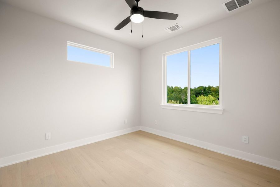 Unfurnished room featuring light wood finished floors and ceiling fan Unfurnished room featuring light wood finished floors and ceiling fan