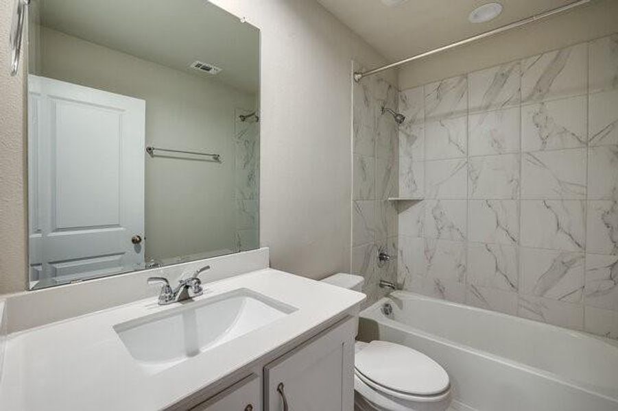 Bathroom featuring toilet, vanity, and bathing tub / shower combination