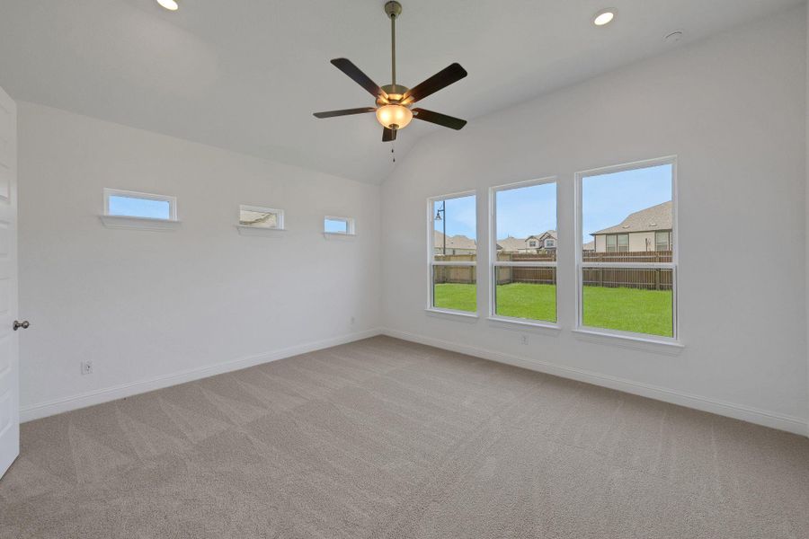 Carpeted spare room featuring vaulted ceiling, ceiling fan, recessed lighting, and a residential view