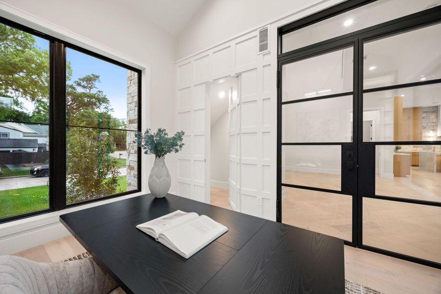 This alternate office view highlights the seamless blend of function and design, with a spacious work surface and thoughtful layout. Natural light enhances the bright and inviting atmosphere. The standout feature is the oversized window framing exterior views, creating an inspiring workspace that feels both open and connected to its surroundings.