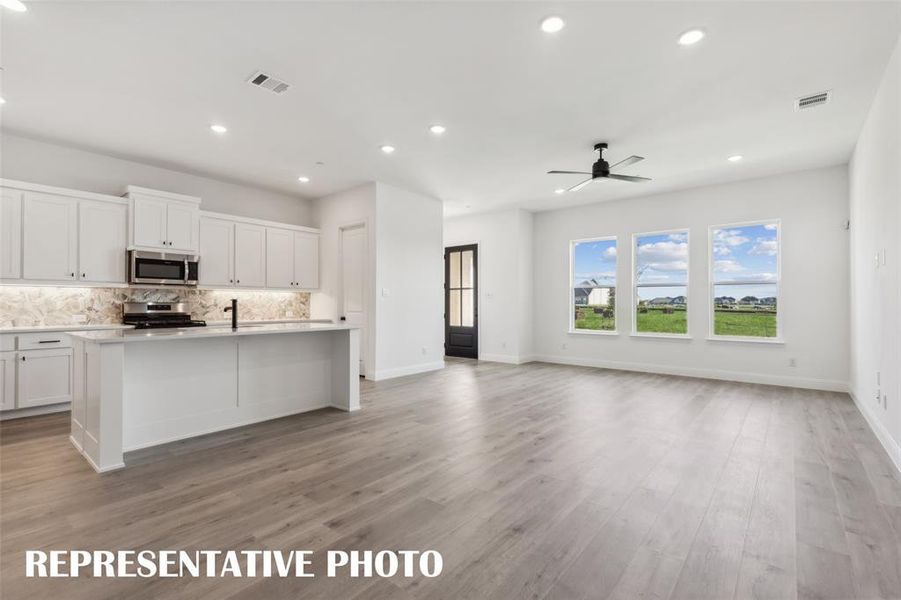 Your new family room offers a wall of windows that flood the home with natural light.  REPRESENTATIVE PHOTO