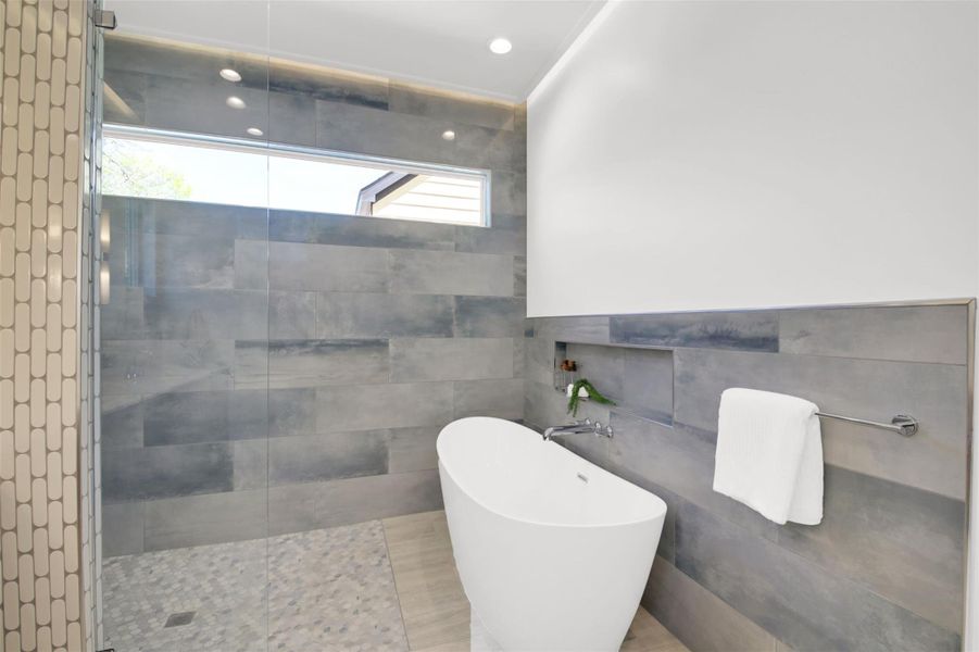 Full bathroom featuring a freestanding tub, walk in shower, tile walls, and recessed lighting