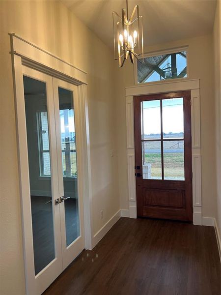 Doorway to outside with french doors, dark hardwood / wood-style floors, and an inviting chandelier