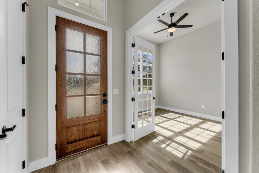 Entrance foyer with light wood-style flooring and a ceiling fan