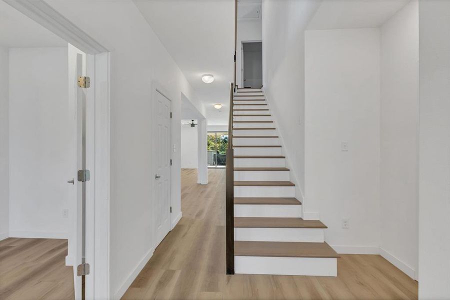 Stairs with wood finished floors and baseboards