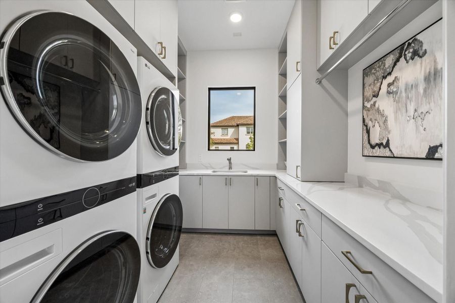 The laundry room contains two washers and two dryers plus ample storage. There is also a large steam closet for steam press and cleaning of hanging clothing. The laundry room contains two washers and two dryers plus ample storage. There is also a large steam closet for steam press and cleaning of hanging clothing.