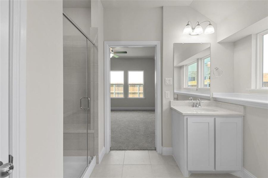 Bathroom with ceiling fan, tile flooring, an enclosed shower, and oversized vanity