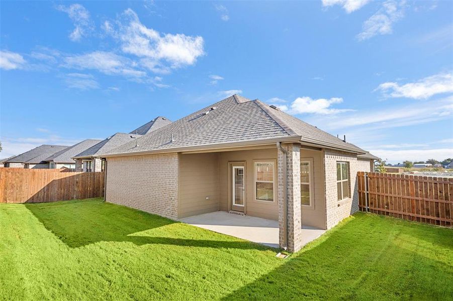 Back of house featuring a shingled roof, a patio, a fenced backyard, and brick siding