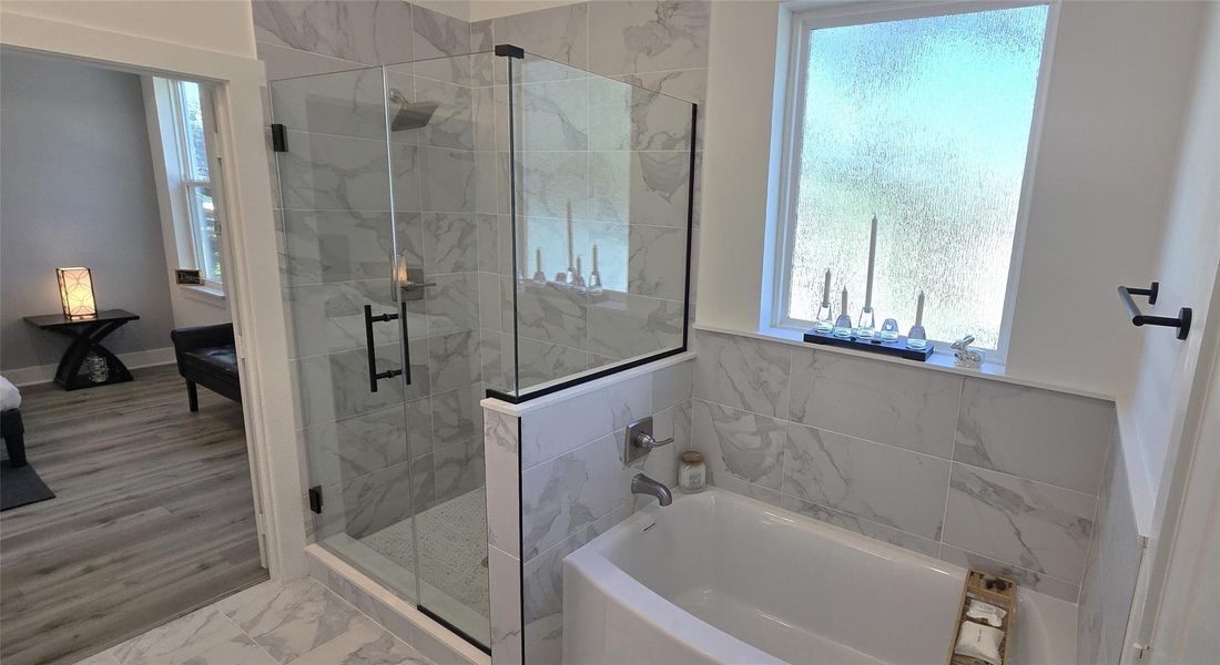 Separate glass enclosed shower and soaking garden tub