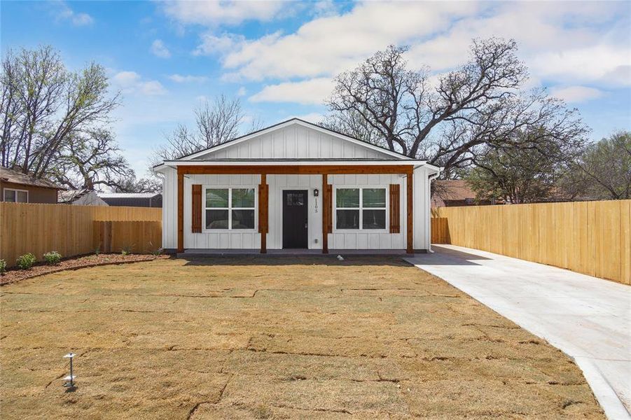 View of front of home featuring fence, a front lawn, board and batten siding, driveway, and a porch View of front of home featuring fence, a front lawn, board and batten siding, driveway, and a porch