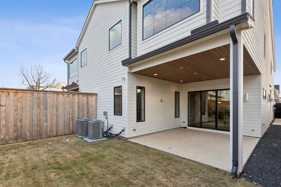 Back of property with a yard, central AC unit, and a patio