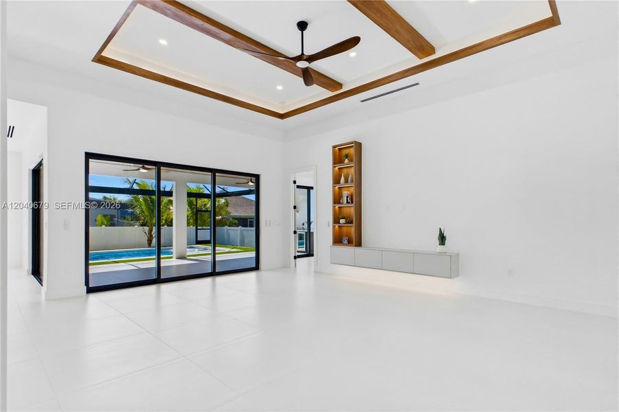 Breathtaking great room featuring soaring 16-foot cove ceiling accented by wood beams & custom trim