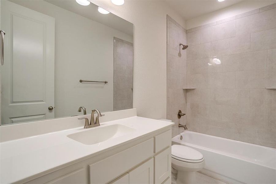 Full bathroom with tiled shower / bath, toilet, and vanity