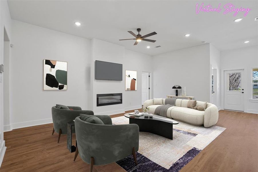 Living room featuring recessed lighting, wood finished floors, and a glass covered fireplace