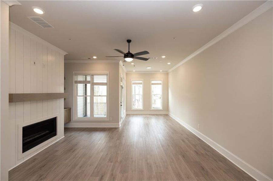 Family room space includes sunroom area and access to back deck with a White Shiplap surround and 42" Ventless Fireplace.