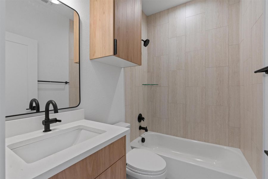 A well-lit bathroom showcases contemporary fixtures and a sleek vanity with ample storage. A well-lit bathroom showcases contemporary fixtures and a sleek vanity with ample storage.