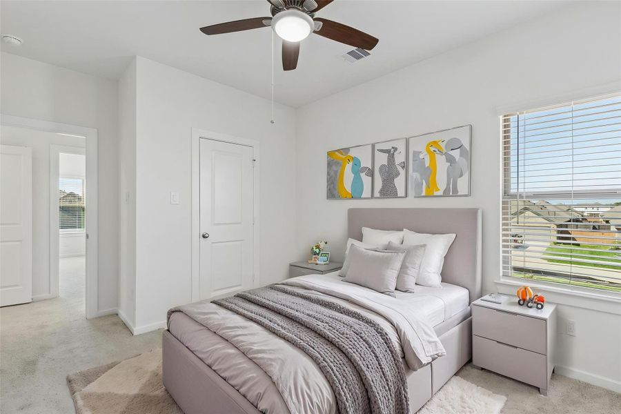 This functional bedroom features neutral carpet, a ceiling fan, and Low-E windows. Virtually staged as a child's room to showcase the potential of this bright, energy-efficient space.