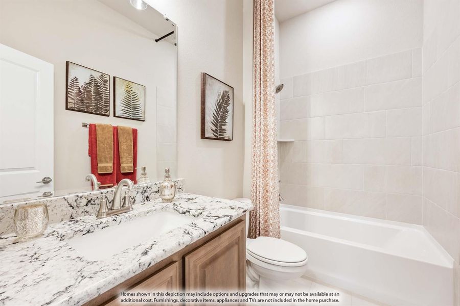 Bathroom with granite countertop vanity, tub-shower combo with tile surround, and wood cabinets