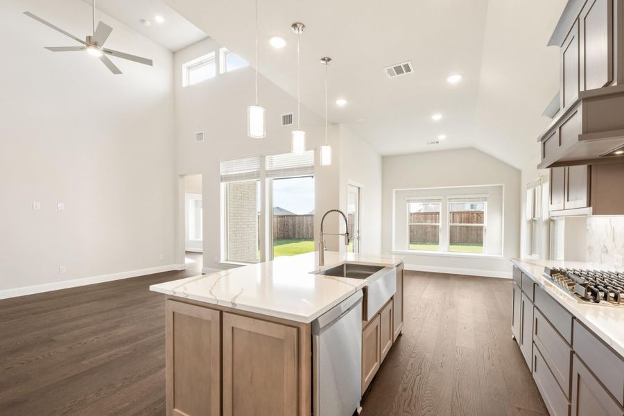 Open kitchen with large island, quartz countertops, high ceilings, and dark hardwood floors Open kitchen with large island, quartz countertops, high ceilings, and dark hardwood floors