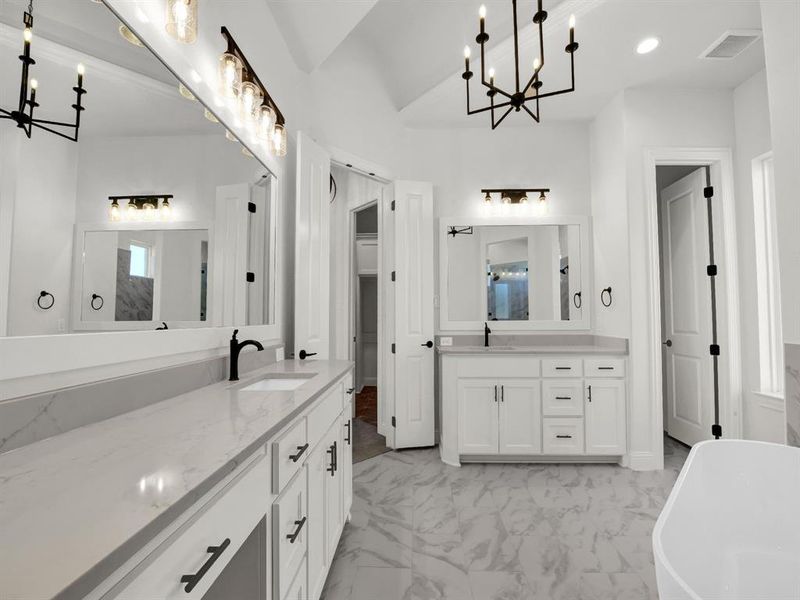 Bathroom with vanity, a bath, and a notable chandelier