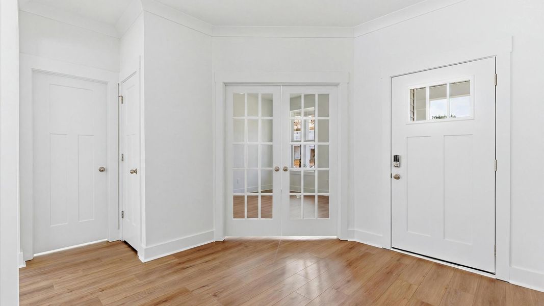 Accomplished hardwood flooring foyer sets the tone for tasteful design throughout this single family home at Foxbank