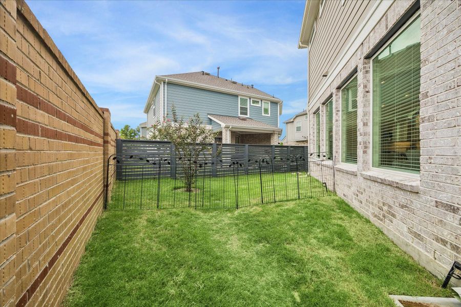The backyard wraps around the home, offering lush yard space for kids or pets to play and enjoy the outdoors.