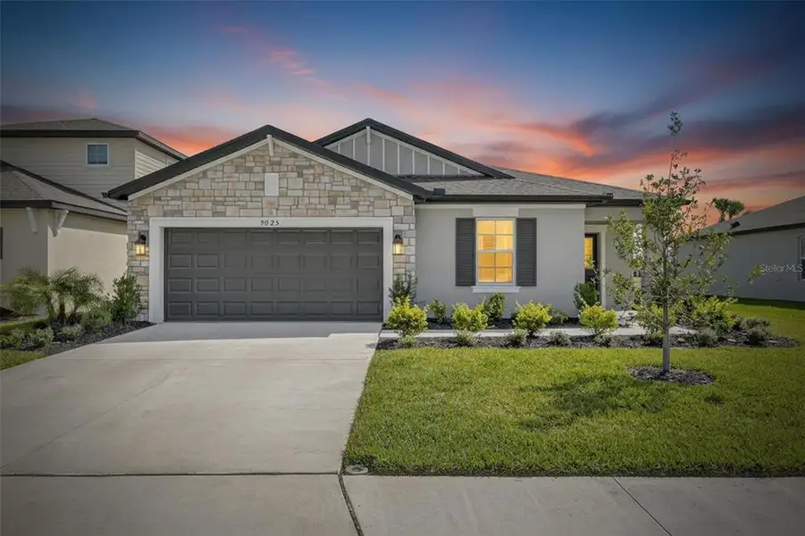 Front exterior of a new home in Summerwoods, Parrish, FL, highlighting curb appeal (Image 26).